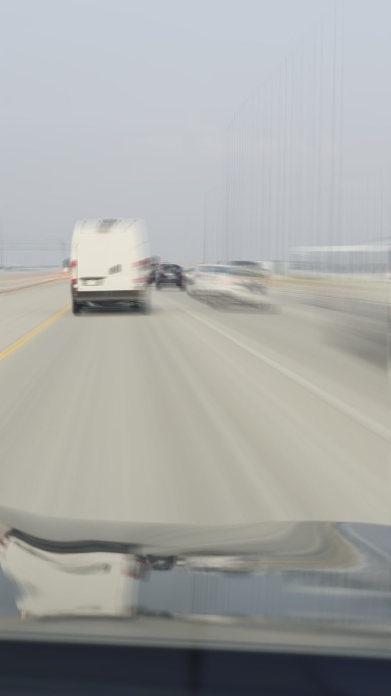 Highway traffic blurred with motion, shot from inside a moving car