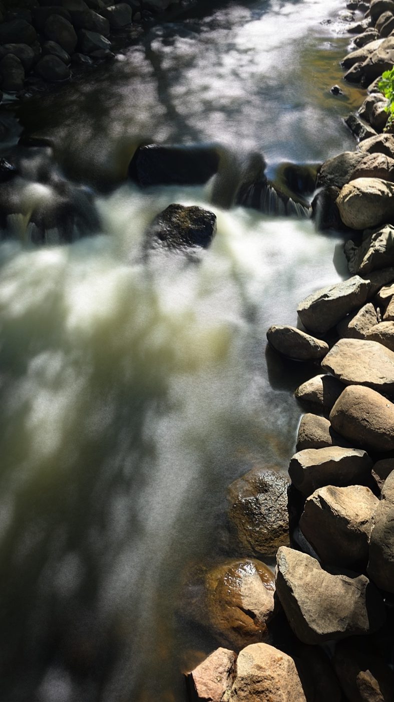 Whitewater rushing between rocks, water misty, rocks sharp